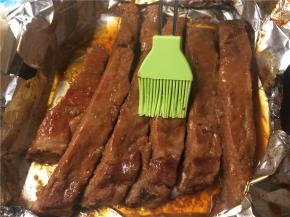 包好的肋排送入预热180度的烤箱烤1个小时后取出，打开锡纸包，使所有的排骨都能露出来，肋排肉多的一面朝上，刷上蜂蜜