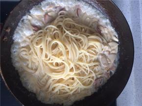 小火将汤汁熬到喜欢的稠度，加入事先煮好的意面，搅拌均匀，是每一根意面都裹上奶汁即可关火