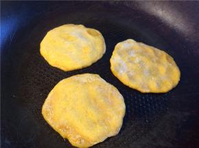 平底锅刷油烧热后转小火，将小剂子压成小圆饼放入，底面煎至金黄后翻面