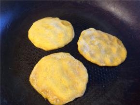 平底锅刷油烧热后转小火，将小剂子压成小圆饼放入，底面煎至金黄后翻面