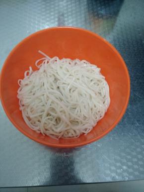 面条煮熟后捞出，装进碗里，然后锅里烧油将小葱煸出香味。