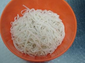 面条煮熟后捞出，装进碗里，然后锅里烧油将小葱煸出香味。