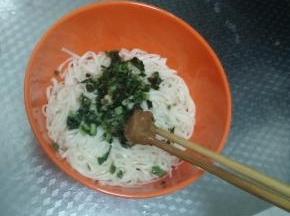 将葱油浇在面条上，然后加上适量鸡精和花生酱进行搅拌