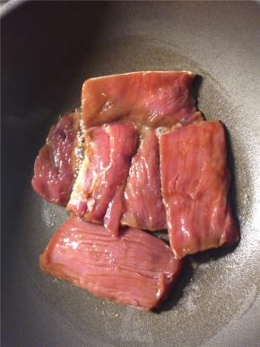 平底锅刷薄油，烧热后放入腌好的里脊肉，转中火煎至两面变色