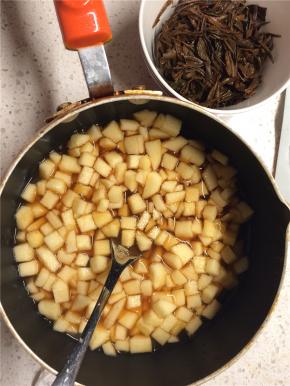 另取一个锅放入苹果丁，加入白糖、柠檬汁搅拌，再加入滤出的红茶水继续搅拌