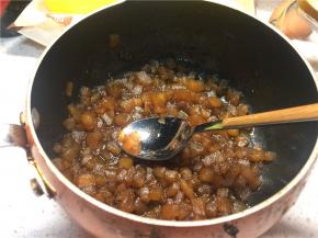 再次开火，大火煮至锅内液体沸腾后转小火煮20分钟左右至汤汁粘稠，关火后趁热用勺子压碎苹果丁，不能全部压碎也没有关系，有一点块状的苹果吃起来口感也会很好
