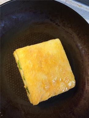 起锅刷一层油，锅热后转小火放入裹满蛋液的吐司，一面煎至金黄后翻面煎另一面