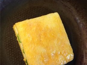 起锅刷一层油，锅热后转小火放入裹满蛋液的吐司，一面煎至金黄后翻面煎另一面