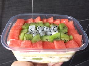 在蛋糕上均匀地挤上奶油，铺上最后一层水果即可，注意一定不要铺太多，以免盖不上盖子