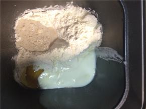 将酵母水、白糖、奶粉、高筋面粉、1个鸡蛋、酸奶一起放入面包机，启动和面程序。