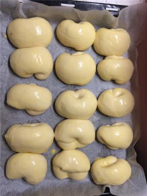 全部摆好后盖保鲜膜于温暖处二次发酵约30分钟至1.5倍大，在发酵好的面团上刷一层蛋液