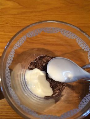 用勺子将酸奶一勺一勺舀到饼干碎上，先倒在四周，最后浇在中间。酸奶浇好后轻轻将杯子在桌面震几下去除气泡，否则会有空隙