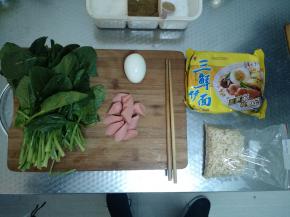 准备好要用到的各种食材，从左到右依次为菠菜、香肠、水煮蛋、三鲜面。香肠切段，泡面拆开。