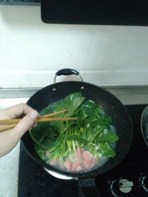 面饼煮散后把洗干净的菠菜放进锅里，用筷子稍微搅拌一下，然后盖上锅盖继续煮三分钟左右。