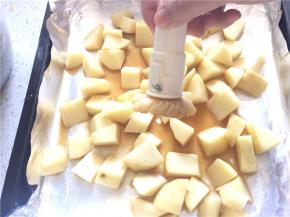 烤盘上垫锡纸，将腌好的土豆均匀地铺在底层，用刷子刷上一层薄薄的食用油