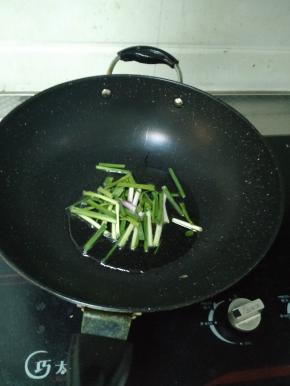 热锅冷油，等油稍微变热后将小葱段倒进锅里，稍微用铲子翻炒，煸出香味。