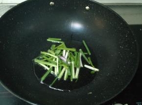 热锅冷油，等油稍微变热后将小葱段倒进锅里，稍微用铲子翻炒，煸出香味。