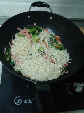 将香肠和蒸面加入锅里，进行翻炒