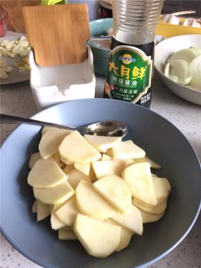 土豆切薄片，加食用油、盐、生抽拌匀，蒜切片、姜切姜丝备用。