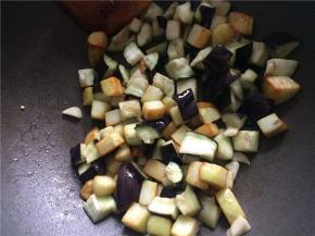 下入蒜末略翻炒后下入微波好的茄子块，翻炒均匀