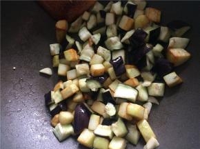 下入蒜末略翻炒后下入微波好的茄子块，翻炒均匀