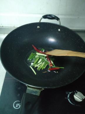 热锅冷油，油热后将小葱和干辣椒倒进锅里，煸出香味。