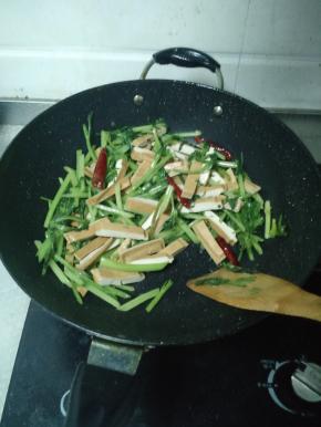 西芹炒到七成熟后将豆干倒进锅里，加酱油、鸡精、十三香、盐巴进行调味。