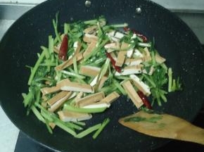 西芹炒到七成熟后将豆干倒进锅里，加酱油、鸡精、十三香、盐巴进行调味。