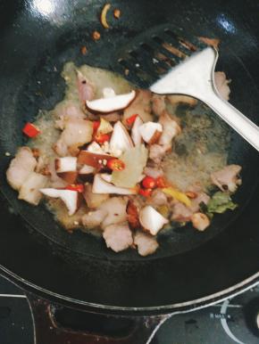 下香菇八角香叶红辣椒继续翻炒5分钟左右，加一小碗水倒入锅里