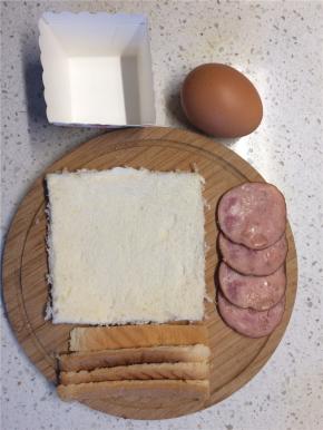 吐司去掉四个边，用擀面杖擀薄，火腿肠切薄片