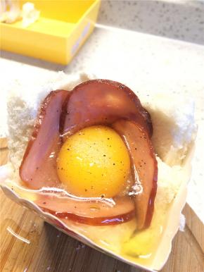 在吐司杯的中间打上一个鸡蛋，撒上盐和黑胡椒