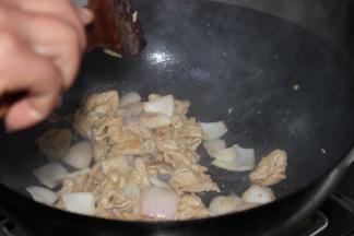 加少许油煸炒洋葱，微微变软时，如图3加入猪大肠继续煸炒3分钟，此时倒入老抽，