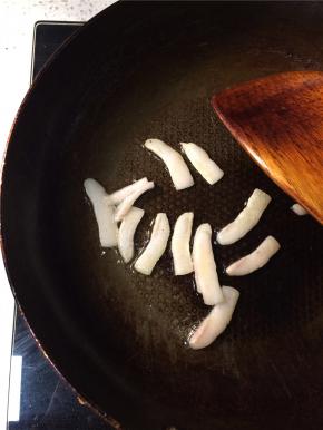 起锅倒入少量底油，油热后下入猪板油，小火将猪油煎出