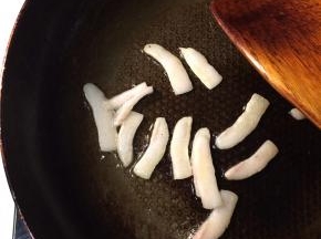起锅倒入少量底油，油热后下入猪板油，小火将猪油煎出