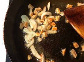 转大火下入蒜片和切段的虾干爆炒一分钟