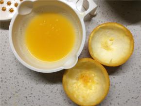 橙子对半切开，果肉榨成橙汁，两片小碗状的果皮用勺子刮干净，务必保证果皮的完整