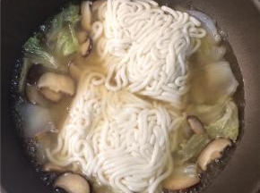 转大火下入乌冬面，煮3分钟左右至面条熟透