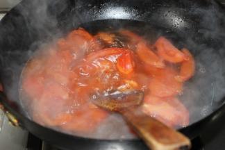 待西红柿至表皮微卷加一大碗水，盖锅等水开