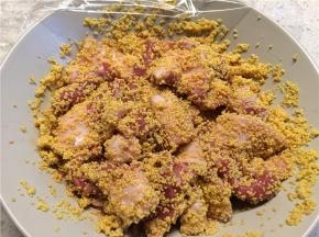 第二天提前一个小时拿出腌制好的猪肉，将已浸泡一夜的小米捞出，和猪肉混匀后，封上保鲜膜继续腌制一个小时