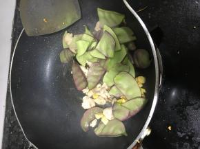 放入五花肉、扁豆翻炒