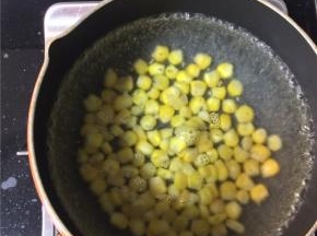 清水烧开后下入甜玉米粒，煮两分钟