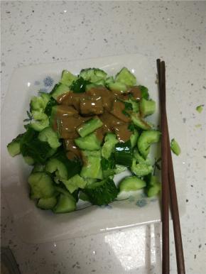 拍碎的黄瓜放入盘子内加入适量的麻酱