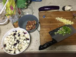 五花肉切碎末，放入嫩肉粉和生抽混合均匀，使肉末更加嫩滑入味；茄子切小块，葱姜蒜切碎末，