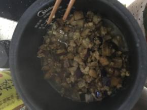 电饭煲如正常煮饭一样加水，把炒好的茄子五花肉盖在饭上正常煮饭即可