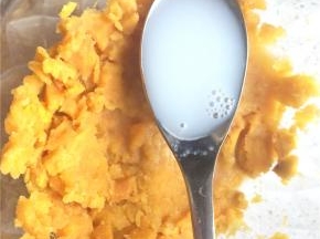 取出蒸熟的红薯，趁热加入牛奶压成细腻绵软的红薯泥。