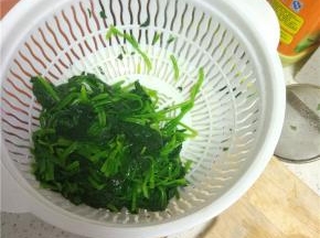 焯过水的菠菜捞出，控干水分