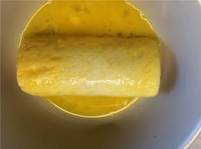 鸡蛋加盐打散，卷好的吐司卷放入蛋液中均匀地裹满蛋液