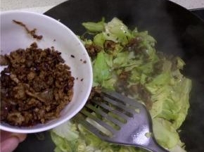 锅内加入包菜进行翻炒，变软之后加入准备好的肉酱