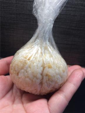 用保鲜膜将米饭包起成球形，可以通过拧紧收口使饭团更紧实