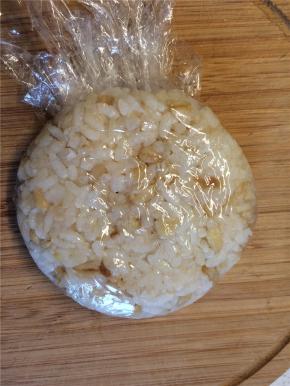 球形饭团放在案板上压扁后去除保鲜膜